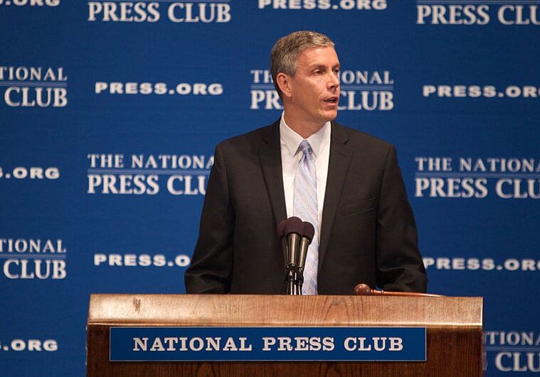 A man in a suit smiling at the camera