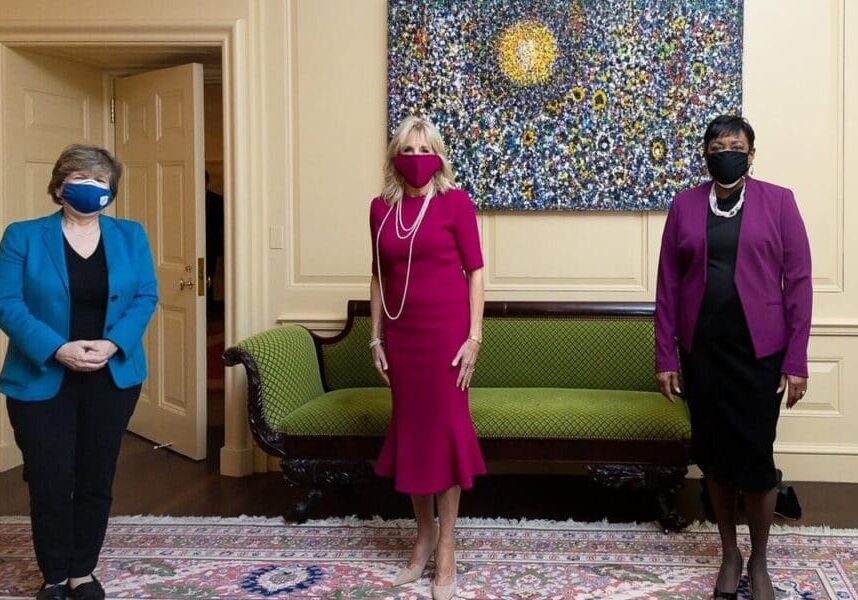 Three women standing together near a sofa