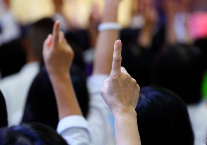 Crowd of people raising fingers in the air