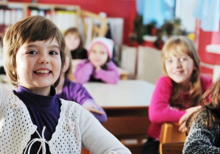 happy young teacher woman at elementrary school teaching and giving leassons to group of young smart children