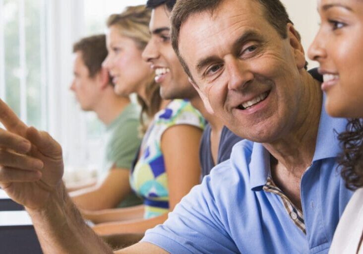 Teacher assisting college student in a computer lab