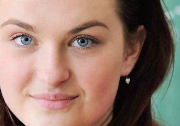 Young school girl with glasses in front of a chalkboard