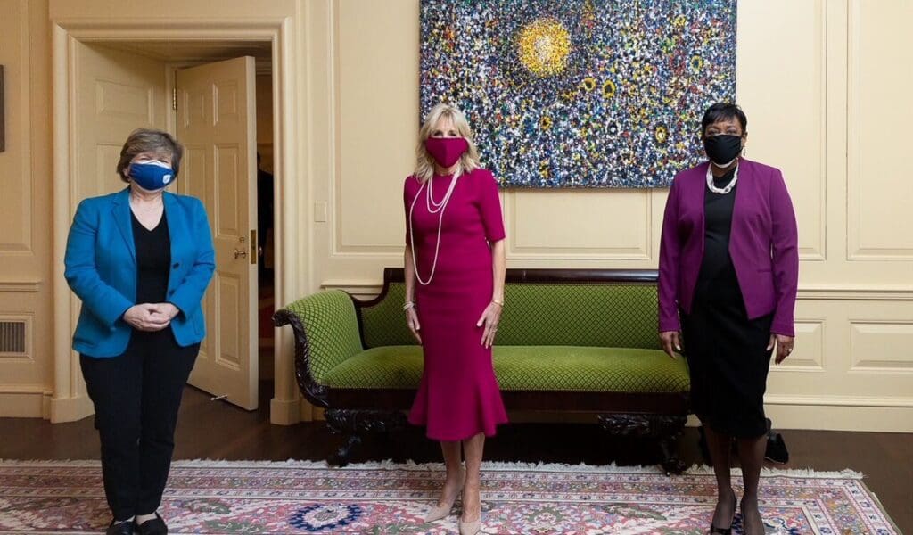 Three women standing together near a sofa