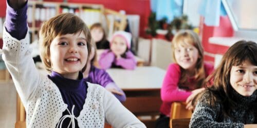 happy young teacher woman at elementrary school teaching and giving leassons to group of young smart children
